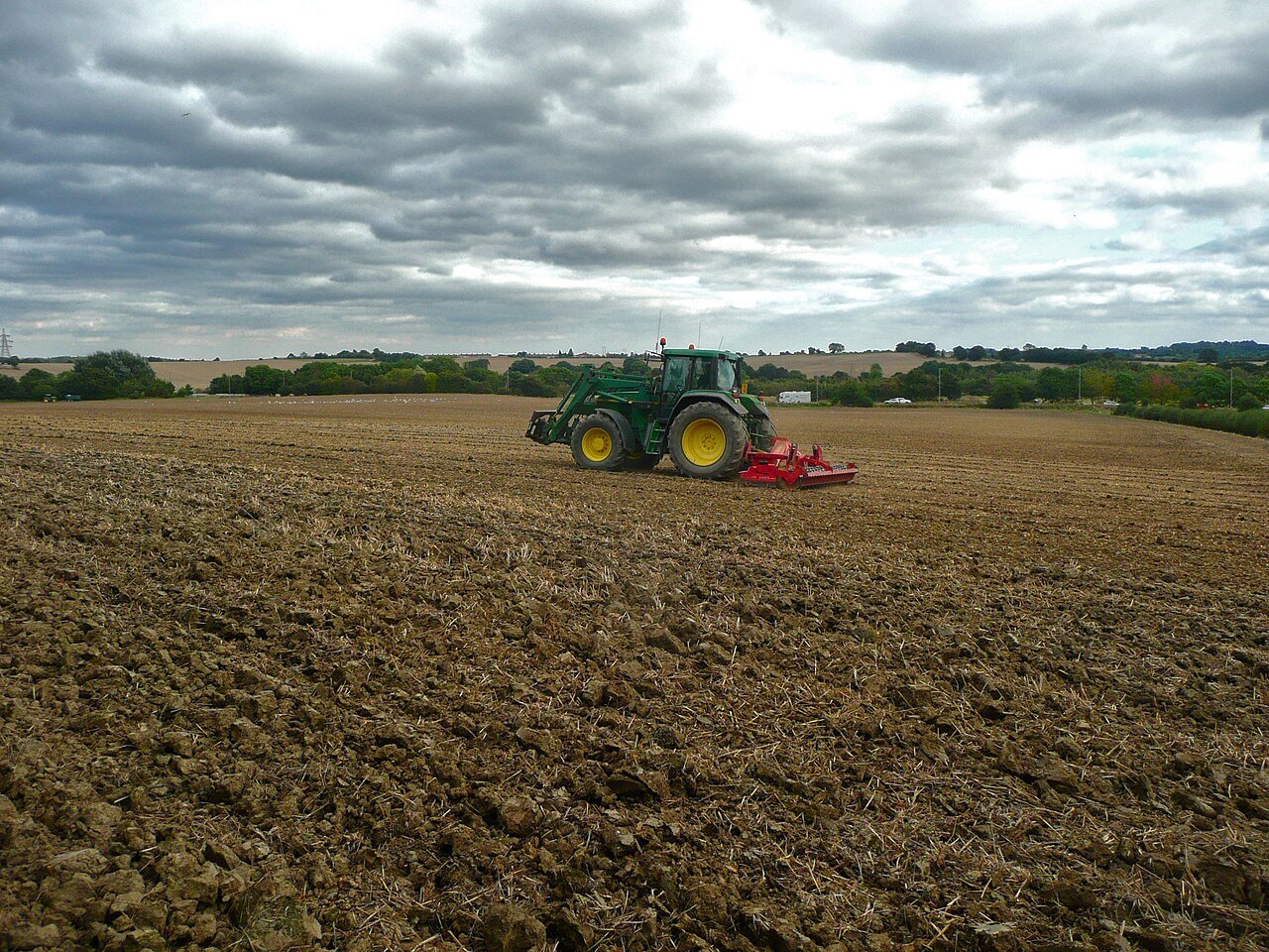 Tractor pulling a disc harrow implement across a field