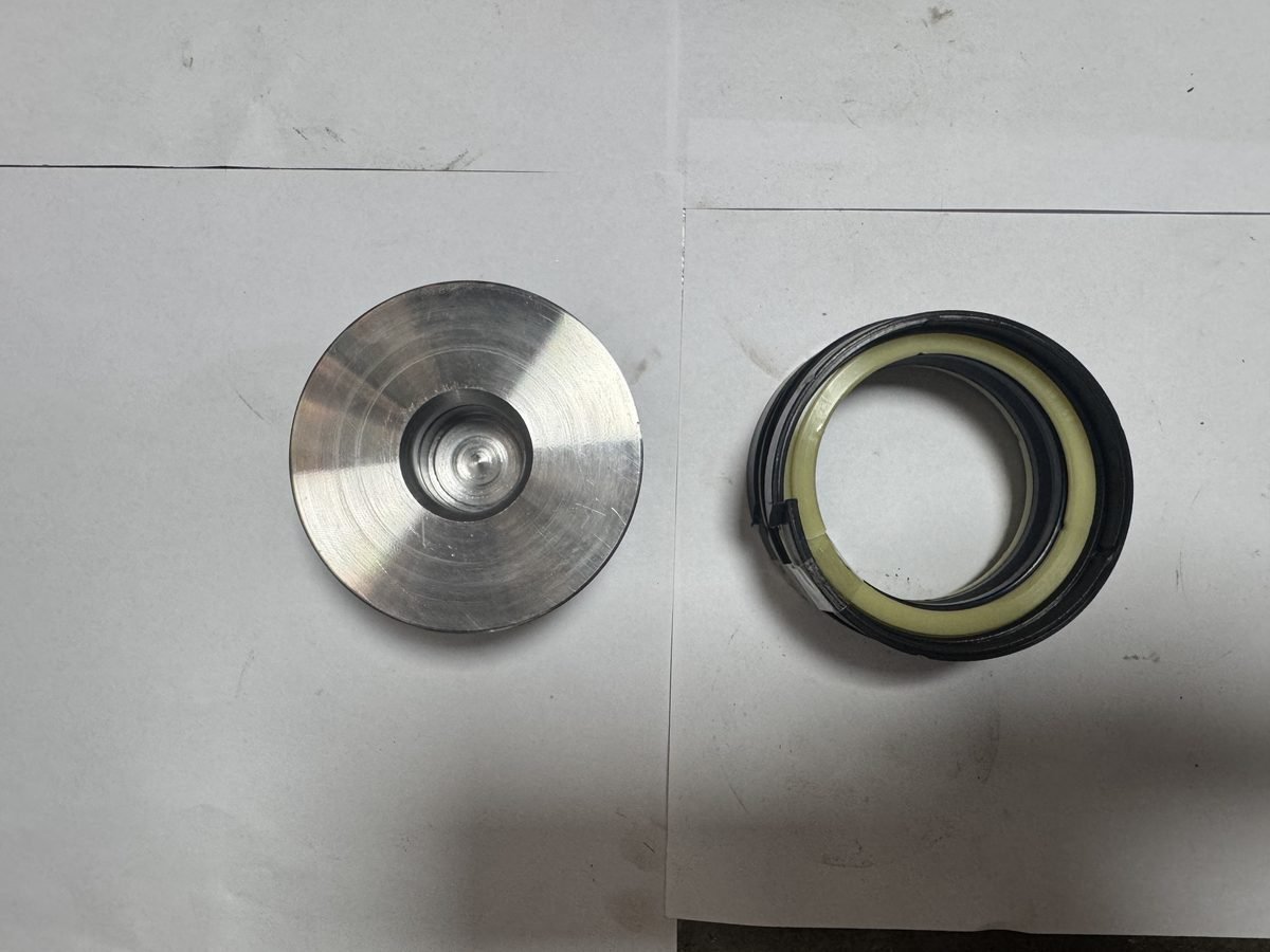 Cylinder piston head, seals and seal kit components laid out for inspection