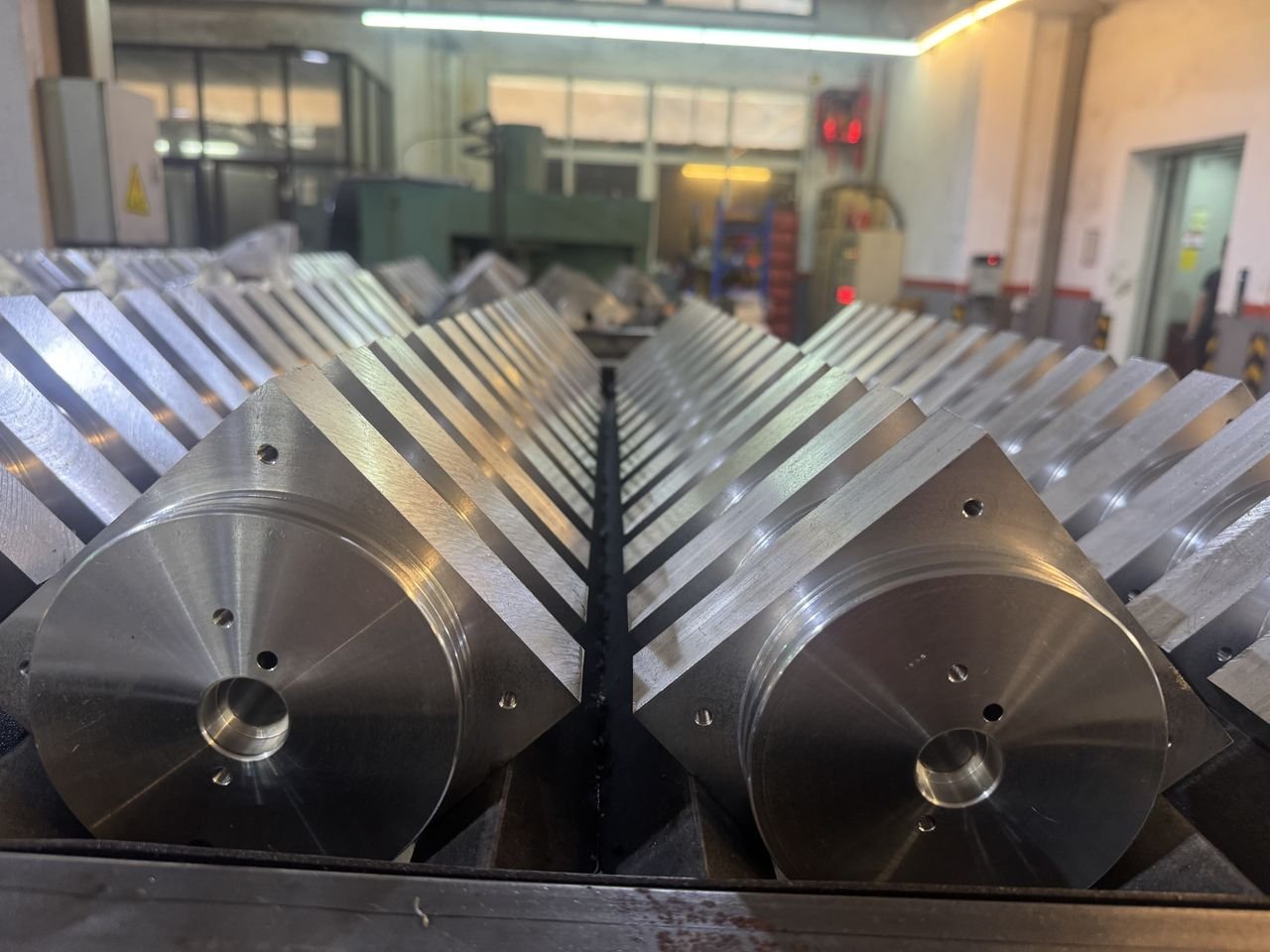 Batch production rows of precision machined steel manifold blocks at the Yilong factory
