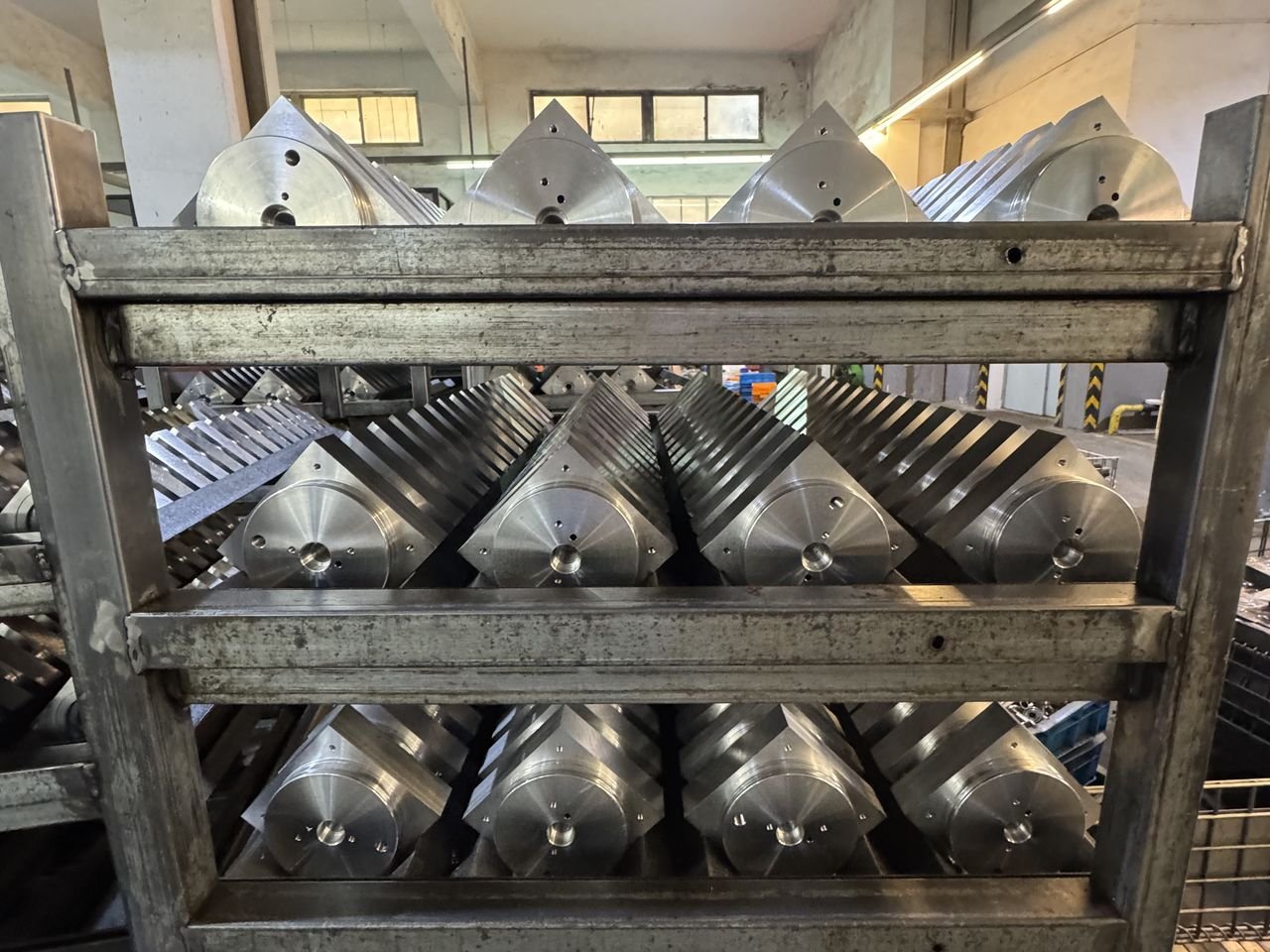 Rack of finished hydraulic valve block bodies in warehouse inventory